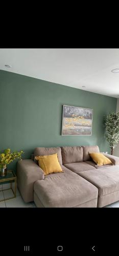 a living room with a brown couch with yellow pillows at Loft Toronjal Studio in La Ceiba