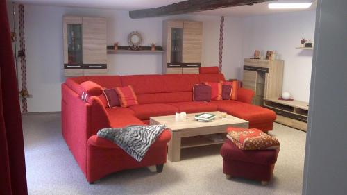 a living room with a red couch and a table at Unseburger Brauhaus GmbH Ferienwohnung 5 in Unseburg