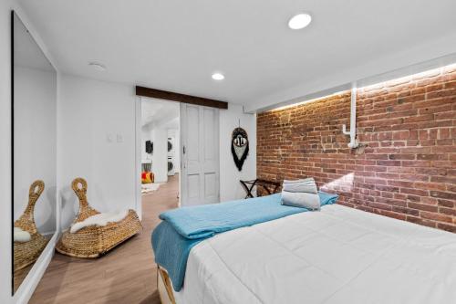 - une chambre avec un mur en briques et un lit dans l'établissement 1616 Vine St Basement Unit, à Denver