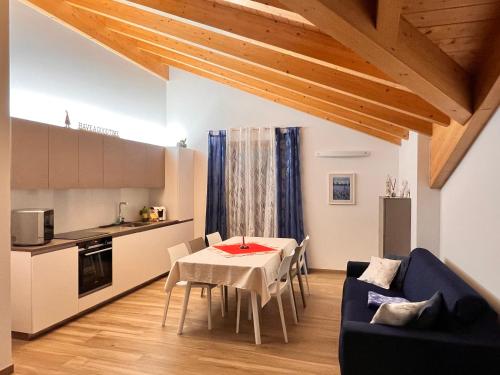 a living room with a table and a kitchen at Ciasa Erica - Val di Non in Predaia