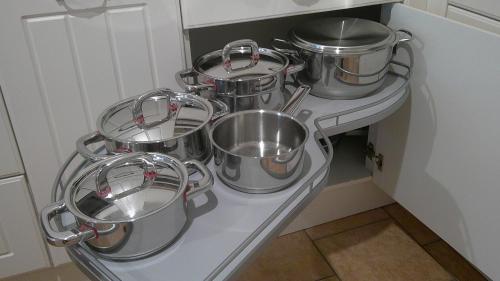 a bunch of pots and pans on a shelf in a kitchen at Unseburger Brauhaus GmbH Ferienwohnung 5 in Unseburg