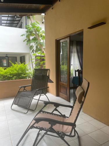 two lawn chairs sitting on a porch of a house at Villa Hermosa in Playa Hermosa