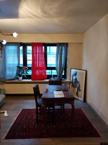uma sala de estar com uma mesa e uma janela em Carpe diem em Gent