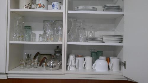 a cabinet filled with glasses and vases and dishes at Unseburger Brauhaus GmbH Ferienwohnung 5 in Unseburg