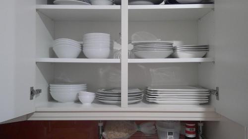a cabinet filled with plates and bowls and dishes at Unseburger Brauhaus GmbH Ferienwohnung 5 in Unseburg