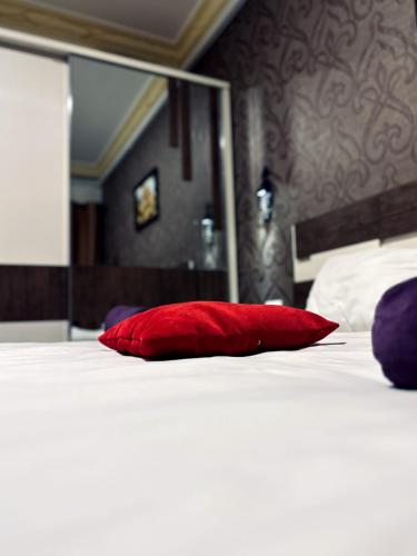 a red pillow sitting on top of a bed at Balcony Hotel in Amman