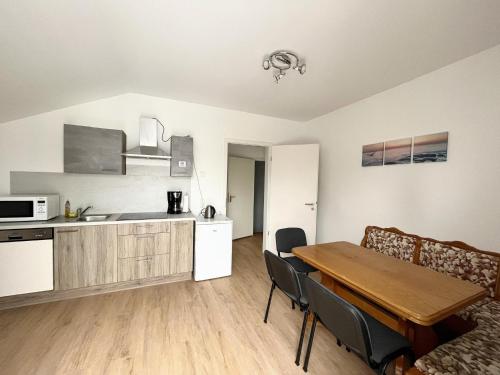 a kitchen and living room with a wooden table and a kitchen and a dining room at Neue Moderne FeWo Europa-Park & Rulantica in Ringsheim