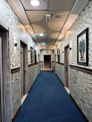 a hallway with a blue carpet in a building at Balcony Hotel in Amman
