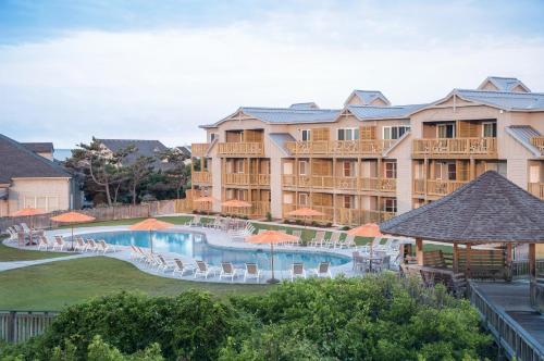 a view of a resort with a pool and chairs at The Sanderling in Duck