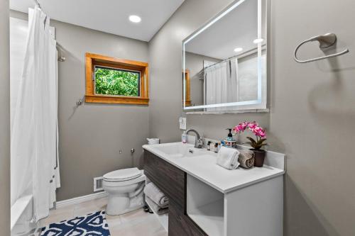 een badkamer met een wastafel, een toilet en een spiegel bij 3875 Dover St - Wheat Ridge in Wheat Ridge