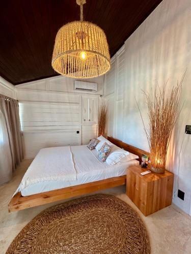 a bedroom with a large bed and a chandelier at Villa Mango in Icaraí