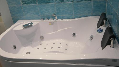 a white bath tub with a faucet in a bathroom at Unseburger Brauhaus GmbH Ferienwohnung 5 in Unseburg