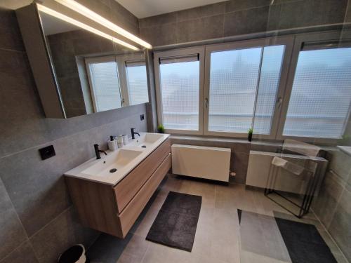 a bathroom with a sink and a mirror at Luxueus, ruim appartement op 350m van het strand in Ostend