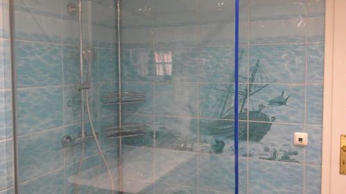 a bathroom with a shower with a boat painted on the wall at Unseburger Brauhaus GmbH Ferienwohnung 5 in Unseburg