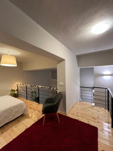 1 dormitorio con 1 cama, 1 silla y 1 alfombra roja en Celeste Loft, en Tríkala