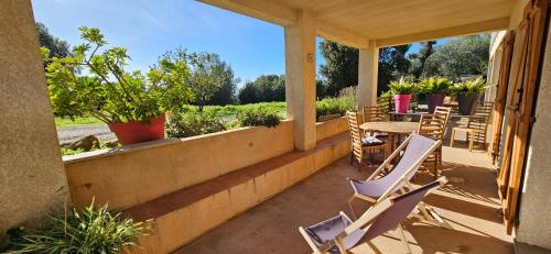 - une terrasse couverte avec des chaises, une table et une table dans l'établissement T3 paisible quartier Vigna Maggiore, Olmeto, à Olmeto