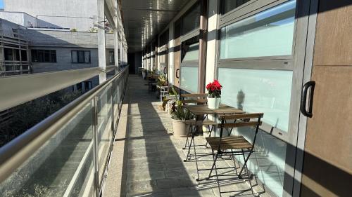Un balcón vacío con mesas y sillas en un edificio en CaseOspitali - Casa Navigli Watt, vicino al Naviglio, originale e luminoso bilocale per 4 con tutti i comfort, en Milán