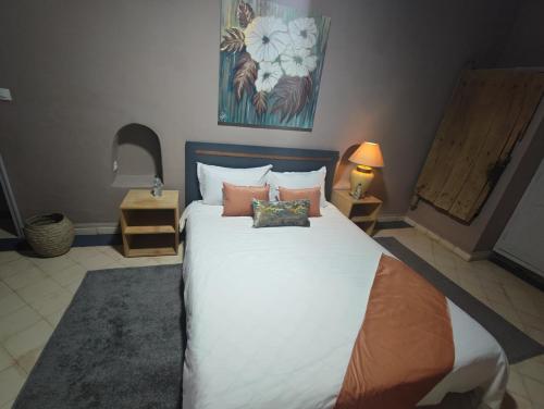 a bedroom with a large white bed with pillows at Hôte sahara & spa TADIGHOUST in El Hara