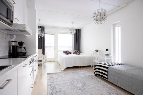 Cet appartement blanc comprend un lit et une cuisine. dans l'établissement City Island Studio Apartment, 4 beds, free street parking with parking disc, bus stop 200m, à Helsinki
