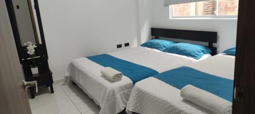a bedroom with two beds with blue and white sheets at Hotel Mykonos Manta in Manta