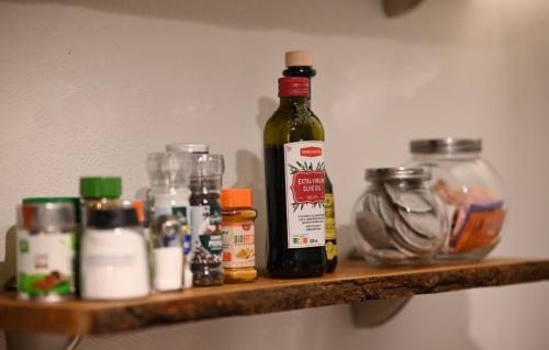a shelf with a bottle of alcohol and other items on it at Altholzapartment in Kempten in Waltenhofen