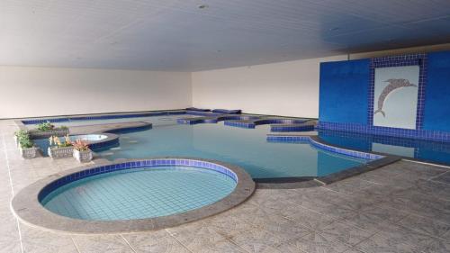 una gran piscina en una habitación grande en Vinha dos Lagos Hotel, en Rancho Queimado