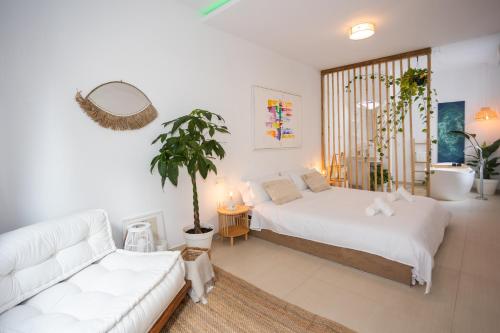 a bedroom with a bed and a couch and a plant at Naim Playa in Cala del Moral
