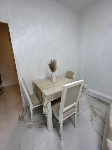 a dining room table with white chairs and a plant on it at Golden House in Dreux