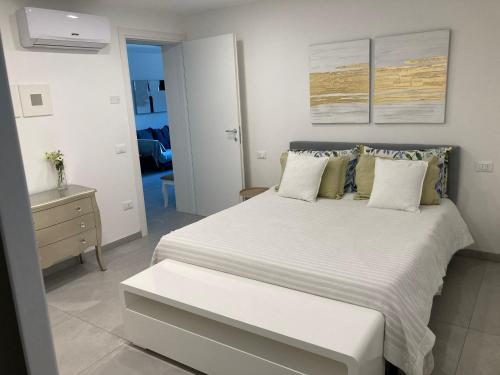 1 dormitorio con 1 cama grande con colcha blanca en Appartamento Casa Roby en Montecatini Terme