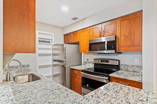 a kitchen with stainless steel appliances and wooden cabinets at M1 - Private and serene 1bdr 1ba ensuite shared room in Atlanta