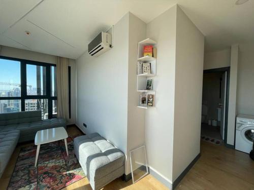 ein Wohnzimmer mit einem Sofa, einem Stuhl und einem Fenster in der Unterkunft Furnished APT (29th floor) with panoramic views in Esenyurt