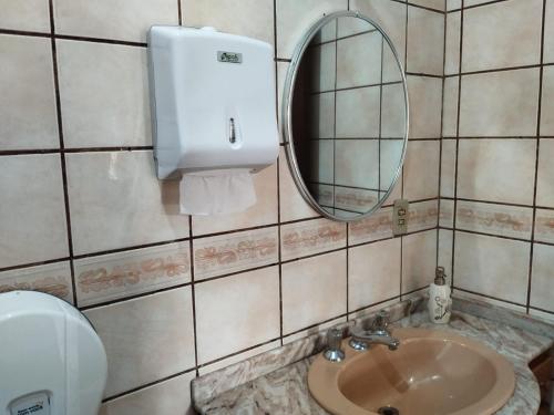 La salle de bains est pourvue d'un lavabo, d'un miroir et de toilettes. dans l'établissement Santa Catarina Hostel, à Florianópolis