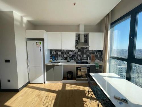 エセンユールトにあるFurnished APT (29th floor) with panoramic viewsの白い家電製品付きのキッチン、大きな窓