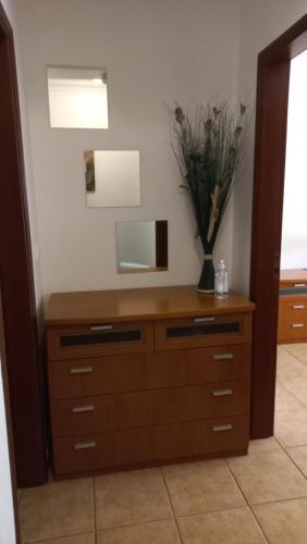 a dresser with a mirror and a vase of flowers on it at Paradise in Cabanas de Tavira in Cabanas de Tavira