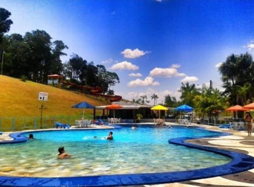 菲格雷多總統鎮的住宿－ECO CHALÉ PARK CACHOEIRAS，和水中的人在度假村的游泳池