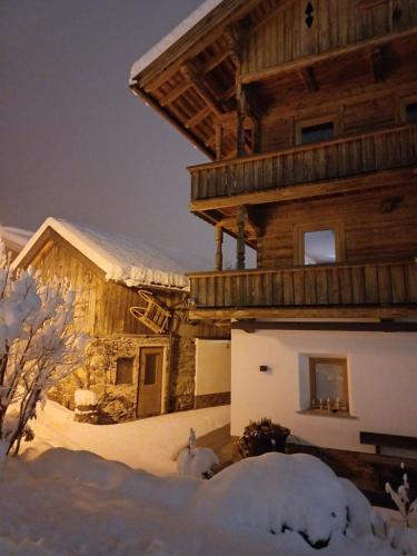 a log cabin in the snow with snow covered at Landhaus Eberler in Mayrhofen