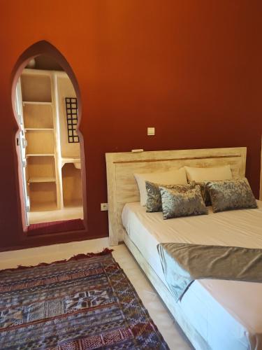a bedroom with two beds and a mirror at Hôte sahara & spa TADIGHOUST in El Hara