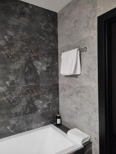 a bathroom with a white sink and a marble wall at Apartament Zamkowe Wzgórze in Lidzbark Warmiński