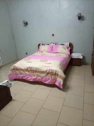 a bedroom with a bed with a pink blanket at RESIDENCE DU PELERIN - Villa l'écrin de verdure à Bandjoun in Bandjoun
