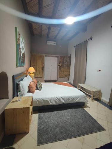 a bedroom with a bed with a person laying on it at Hôte sahara & spa TADIGHOUST in El Hara