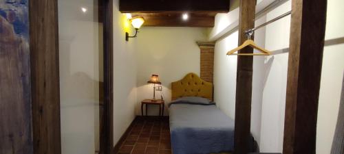 a small bedroom with a bed and a lamp at Hotel Grand Maria in San Cristóbal de Las Casas