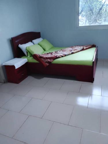 a bed sitting in a room with a white floor at RESIDENCE DU PELERIN - Villa l'écrin de verdure à Bandjoun in Bandjoun