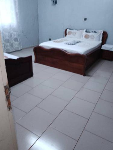 a bedroom with two beds and a white floor at RESIDENCE DU PELERIN - Villa l'écrin de verdure à Bandjoun in Bandjoun