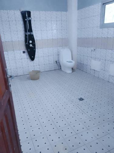 a bathroom with a toilet in a tiled floor at RESIDENCE DU PELERIN - Villa l'écrin de verdure à Bandjoun in Bandjoun