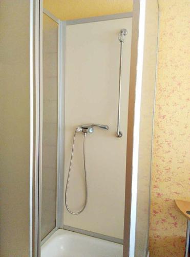 una ducha con cabezal de ducha en un baño en Hotel Yans, en Oberhausen