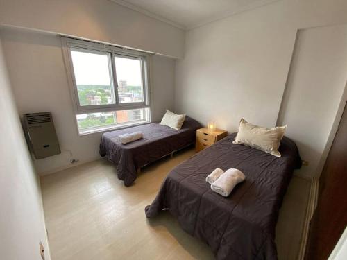 1 dormitorio con 2 camas y ventana en Tigre Center Tower B - Con parking, piscina y seguridad 24hs en Tigre