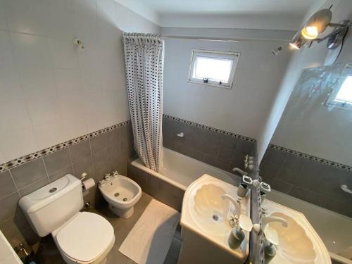 a bathroom with a white toilet and a sink at Tigre Center Tower B - Con parking, piscina y seguridad 24hs in Tigre