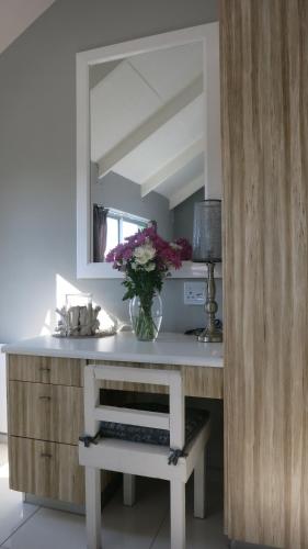 a vase of flowers on a counter in a kitchen at Man And Tree House - De Waterkant in Cape Town