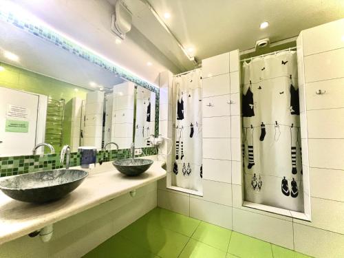 La salle de bains est pourvue de 2 lavabos et de 2 miroirs. dans l'établissement Kust Hostel, à Kiev