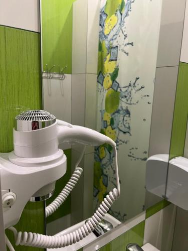 a bathroom with a hair dryer and a mirror at Kust Hostel in Kyiv